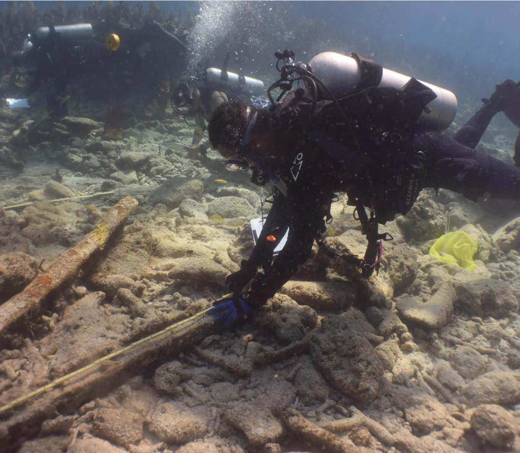 Scuba diver inspecting undersea wreckage