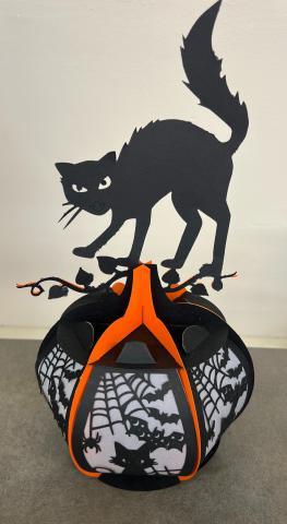 Paper lantern of a cat on top of a spooky pumpkin.