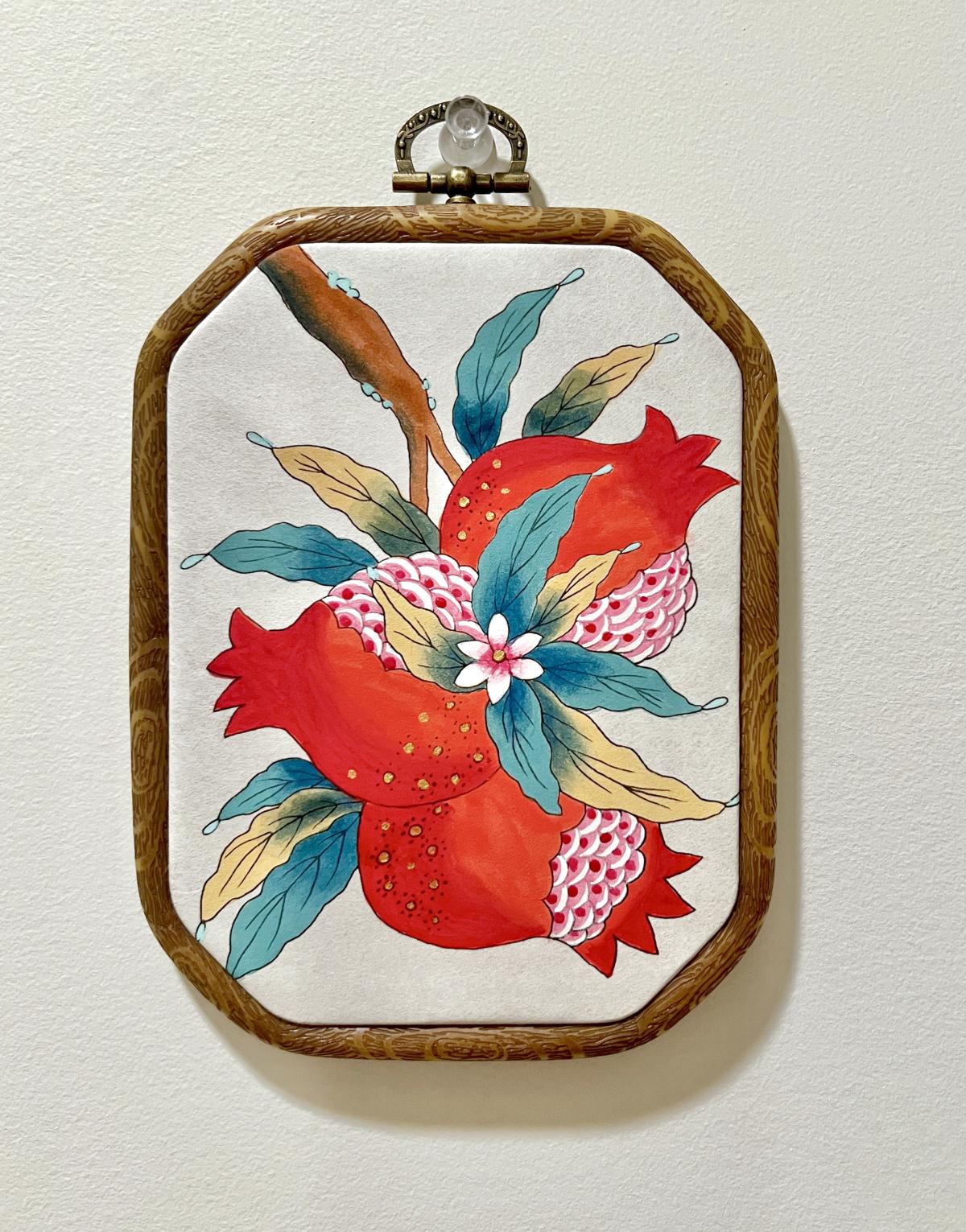 painting of two pomegranates, with some leaf details in the background